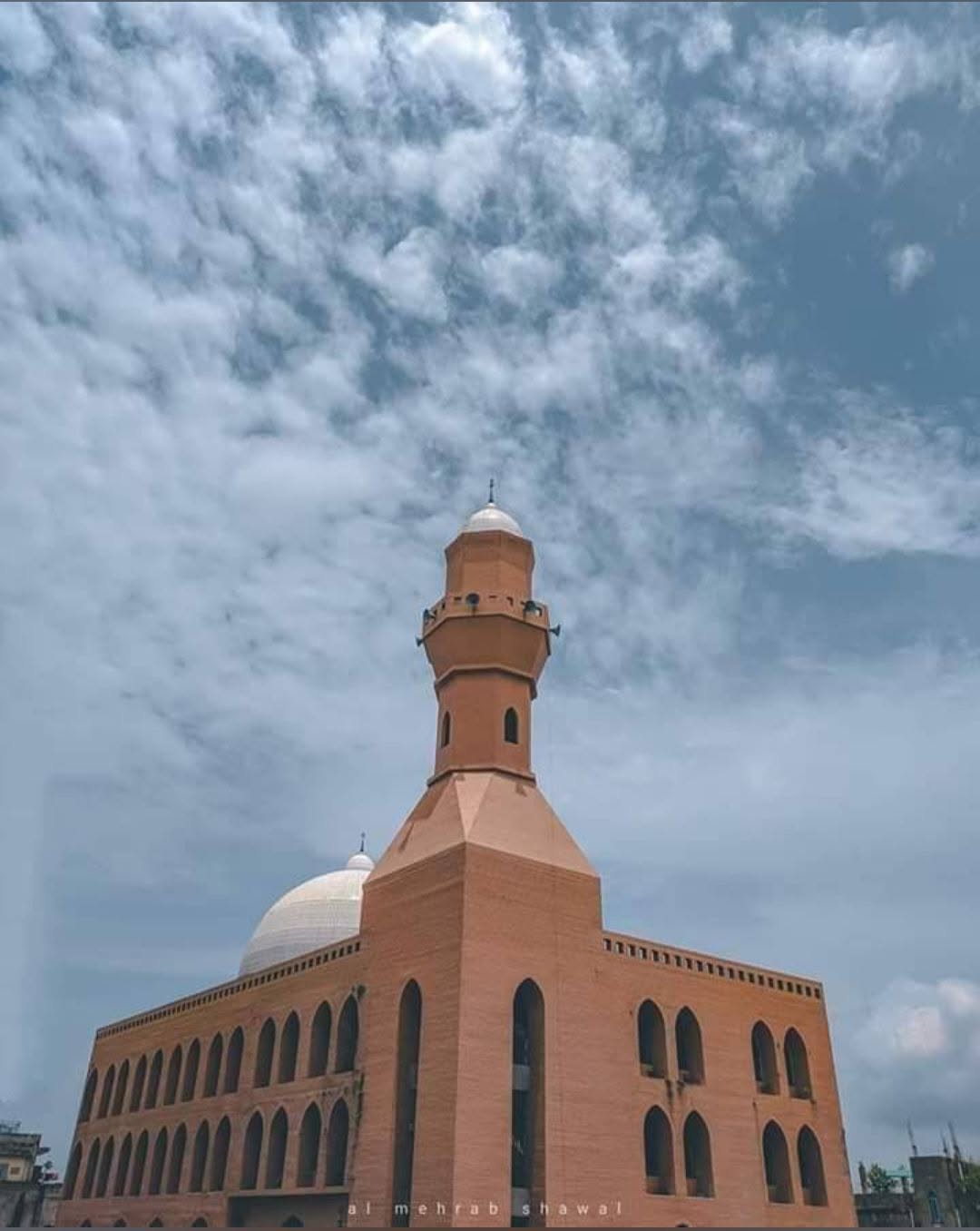 The dome and minaret of the madrasa beneath a bright Brahmanbaria sky